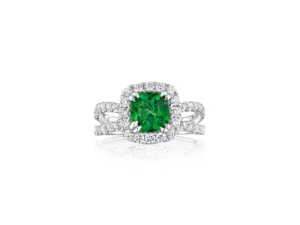 A white gold engagement ring with a cushion-cut green emerald center stone surrounded by a halo of diamonds.